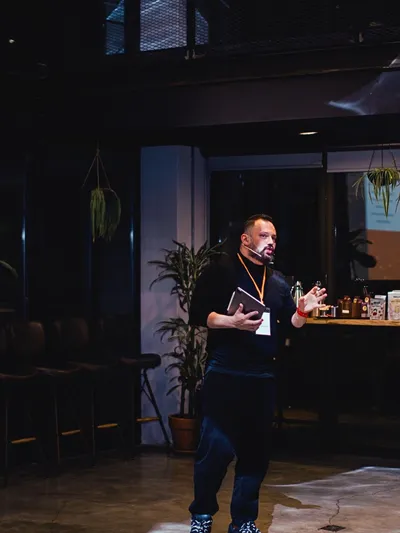 Ulaş Gökhan Gümüş loft mekânda ayakta sunum yaparken.