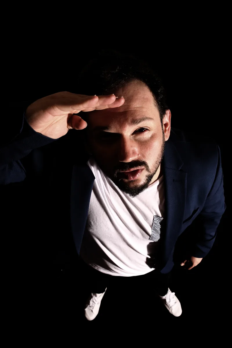 Ulaş Gökhan Gümüş — keşif pozu, el alında ufka bakış.